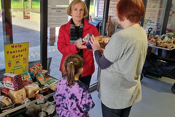 Susan Murray with a woman and a young girl at GRACE's Help Yourself Café.