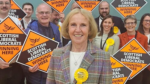 Susan Murray, MP for Mid Dunbartonshire, with activists behind holding orange diamonds.