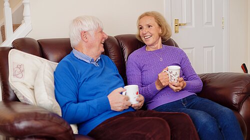 Susan Murray and a resident on a couch chatting