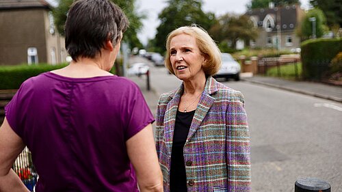 Susan chatting with a local resident on the street