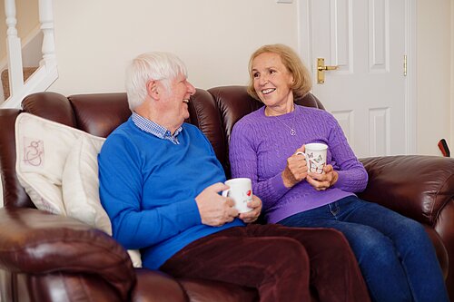 Susan Murray and a resident on a couch chatting