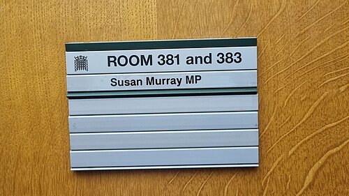 Sign on wooden door reading "Room 381 and 383. Susan Murray MP"