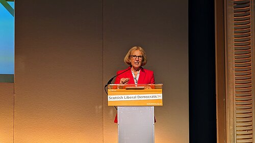 Susan Murray standing at a podium.