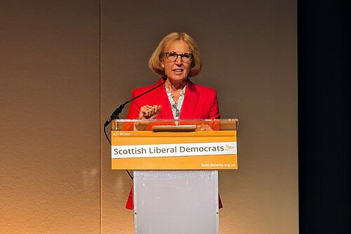 Susan Murray standing at a podium.