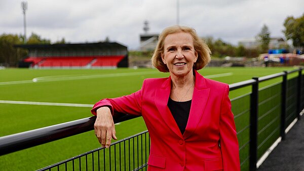 Susan Murray, Mid Dunbartonshire candidate for the Scottish Liberal Democrats, leaning on a fence next to a football pitch.
